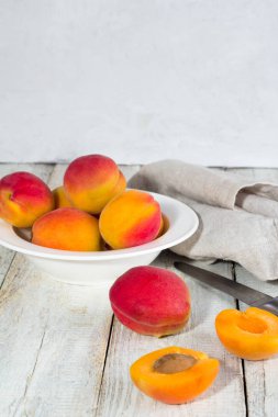 Beyaz bir arka plan üzerine bir tabak içinde kayısı