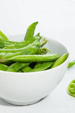 Tabakta beyaz bir zemin üzerinde yeşil bezelyeler