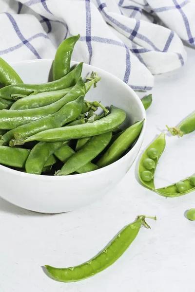 Beyaz bir tabak içinde yeşil bezelye