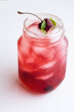 Buz, kiraz ve fesleğen beyaz zemin üzerine kırmızı içecek