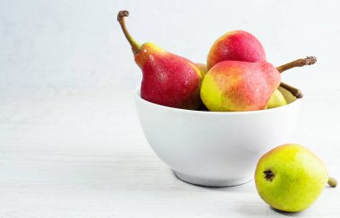 Beyaz bir arka plan üzerinde beyaz bir tabak içinde kırmızı armut