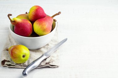 Beyaz bir plaka, bıçak beyaz zemin üzerine kırmızı armut