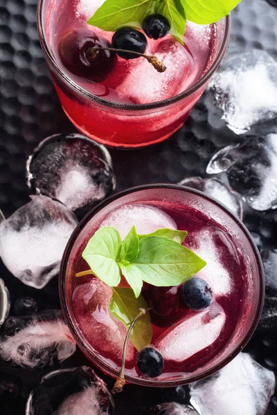 Rode drankje met basilicum en bessen bovenaanzicht op een zwarte achtergrond — Stockfoto