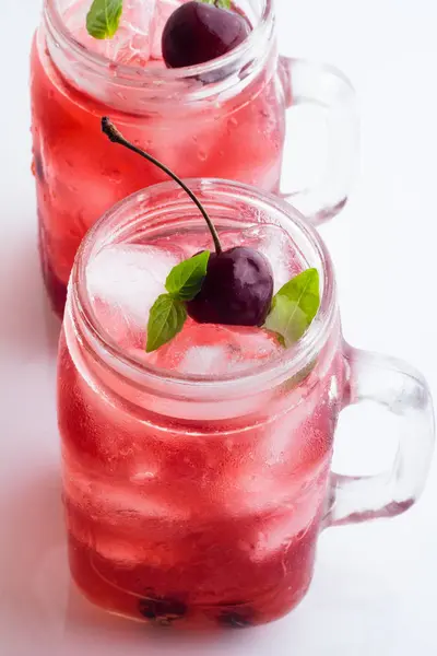 Glazen mokken met een rode drankje, bessen en ijs — Stockfoto