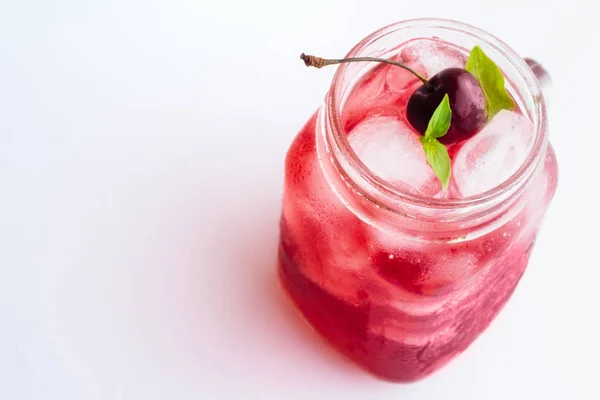 Red drink with ice and cherry on a white background — Stock Photo, Image