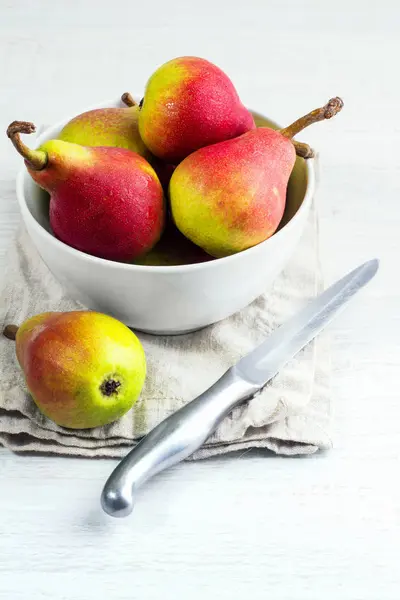 Beyaz bir tabak içinde kırmızı armut bıçak