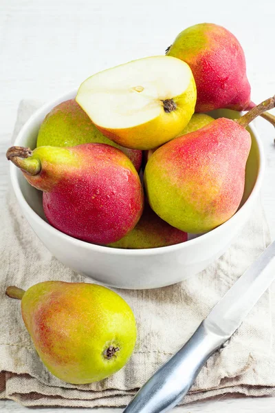 Beyaz bir plaka, bıçak beyaz arka plan üzerinde kırmızı armut