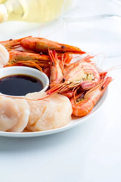 Karides ve beyaz bir tabak, bir şişe şarap ve bardak soya sosu