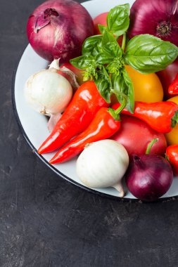 siyah bir zemin üzerine bir tabakta sebze çeşitli