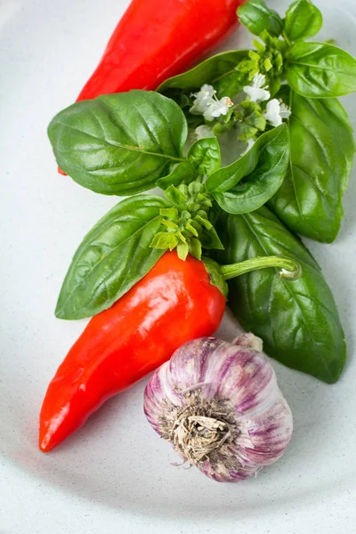 kırmızı biber, sarımsak ve fesleğen yaprakları üzerinde beyaz bir arka plan