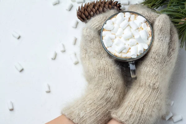Beyaz eldiven tutarak kupa ile sıcak çikolata, kahve ve marshmallow, Noel ağaç dalları, çam kozalakları, Noel oyuncaklar ve beyaz arka plan, kavram Noel ve yeni yıl eller
