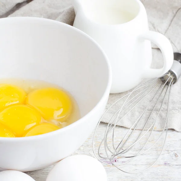 Ovos em uma chapa, leite e batem na imagem quadrada — Fotografia de Stock