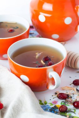 Beyaz arka plan yakın çekim üzerinde kırmızı kupalar otlar ile çay