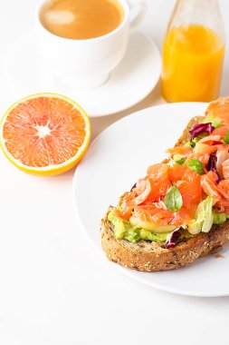 Kahvaltı için somon tostu, kahve ve meyve suyu.