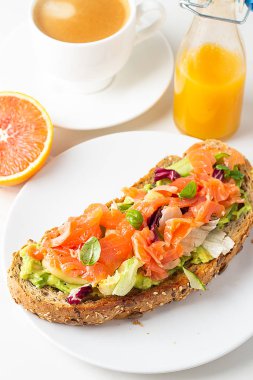 Somonlu tost, salata ve avokado, kahvaltıda sade kahve ve meyve suyu.