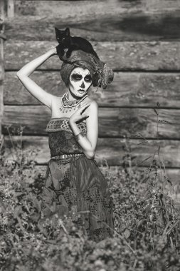 Santa Muerte halloween kılık. Cadı kadın ve kara kedi Cadı ölüm makyaj.