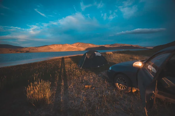 Wunderschöner Sonnenuntergang, Zeltlager und Auto in die Berge. Mongolische Landschaft. — Stockfoto