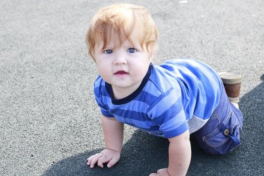 Dört ayak üzerinde kalan mavi gözlü moda zencefil yürümeye başlayan çocuk