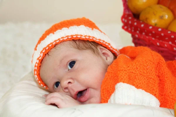 Sorprendido lindo bebé recién nacido vestido con un traje de punto naranja — Foto de Stock
