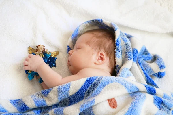 Lindo bebé recién nacido durmiendo en manta azul con figura de ángel — Foto de Stock