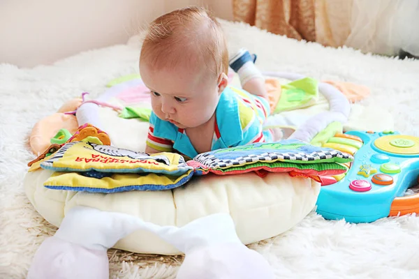 Lindo bebé con cabello de jengibre y ojos azules leyendo un libro o — Foto de Stock