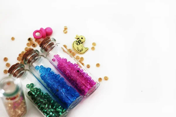 Tiny glass bottles filled with  colored  beads and elements for — Stock Photo, Image