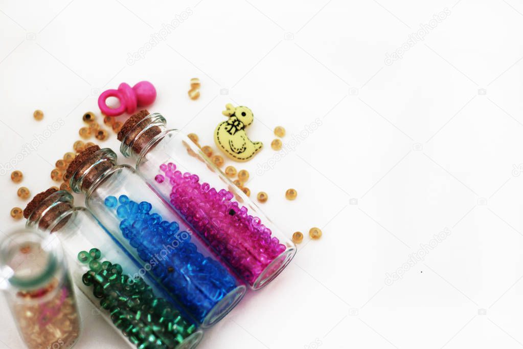 Tiny glass bottles filled with  colored  beads and elements for 