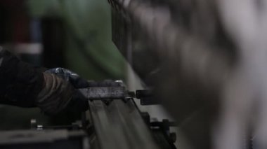 İşçi metal ürünler makine üzerinde eğilir.