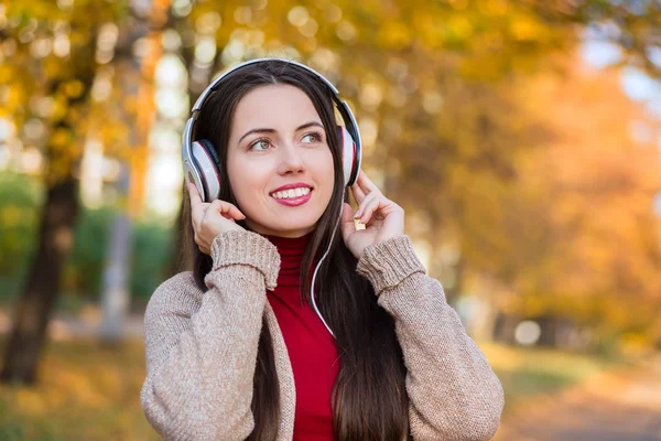 woman with headphones in autumn park