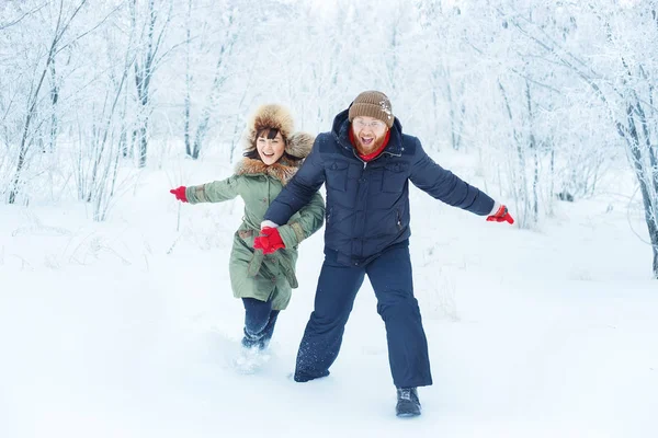 Pareja feliz corriendo en invierno al aire libre — Foto de Stock