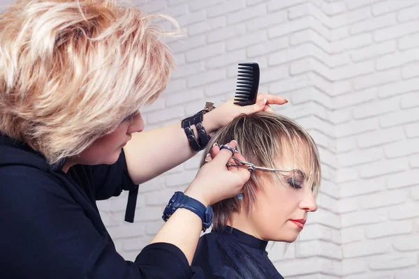 Hairdresser cutting woman hair — Stock Photo, Image