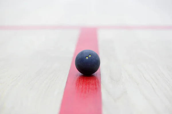 squash ball on red line