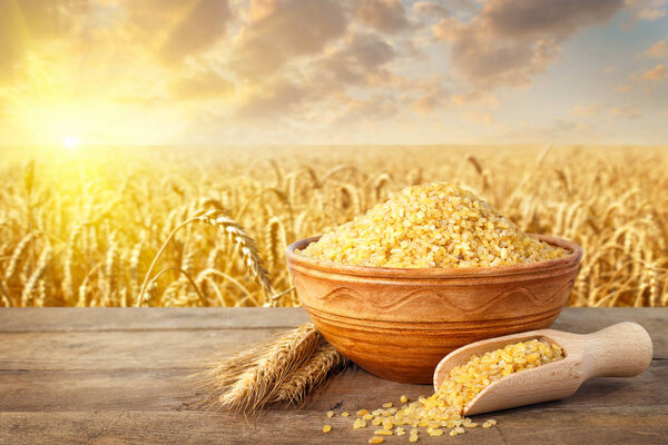 Булгар в миске с полем на заднем плане
