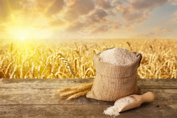 отрубей в мешке и совок на столе
