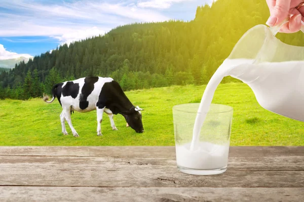 milk from jug pouring into glass