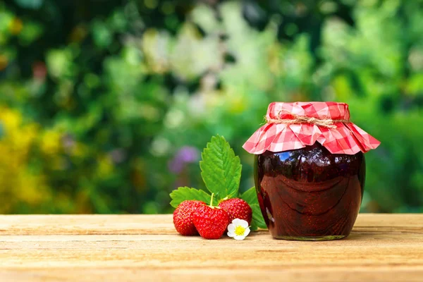 Jordbærsyltetøj i krukke på bordet - Stock-foto