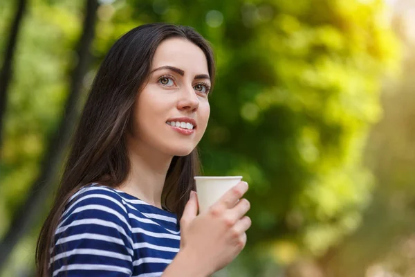 woman holding disposable cup of coffee