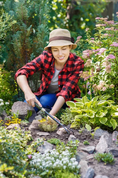 Giardiniere donna cura dei fiori in giardino — Foto Stock