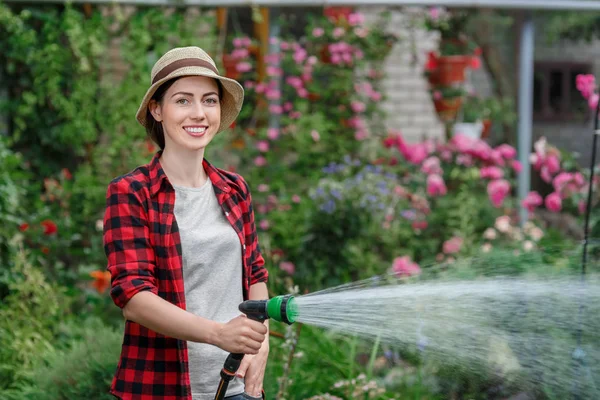 Жінка садівник полив саду — стокове фото