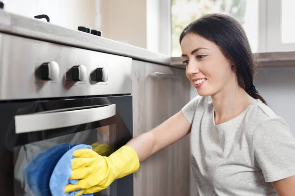 Donna felice pulizia forno — Foto Stock