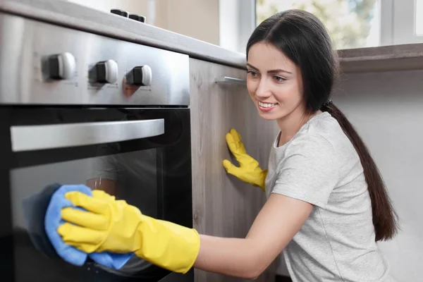 Frau poliert Backofen — Stockfoto