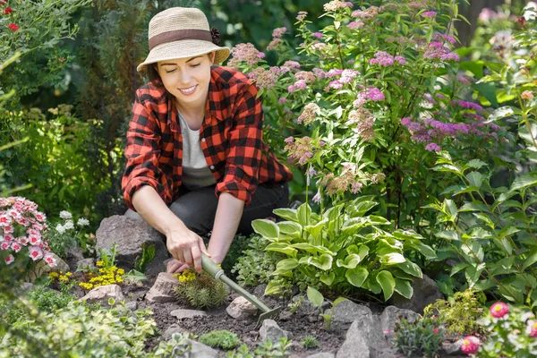 Woman gardener weeding weeds — Stock Photo, Image