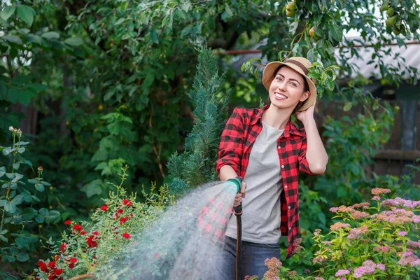 Donna giardiniere irrigazione giardino — Foto Stock