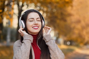 Kız sonbahar Park müzik dinleme