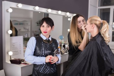 Makyaj öğretmen tutarak fırçalar