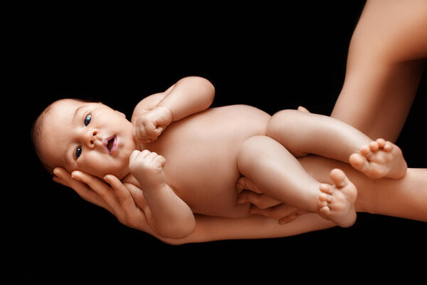 mother hands holding newborn baby