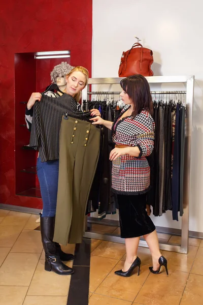stylist helping chooses clothes for the customer
