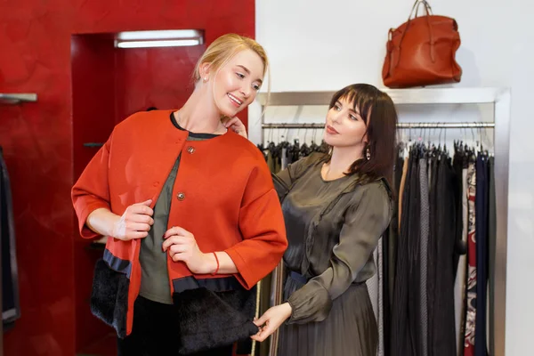 Ayudante de tienda ayuda elige la ropa — Foto de Stock