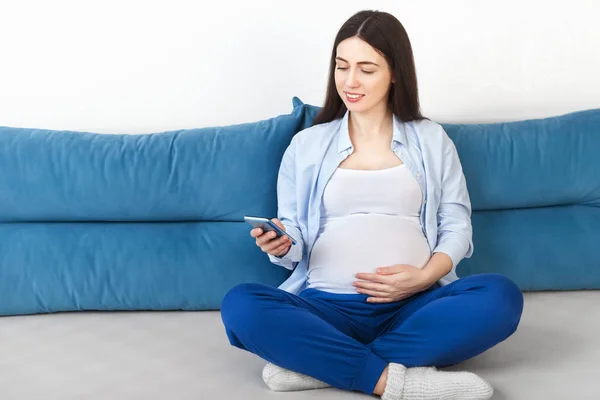 Mujer embarazada usando smartphone — Foto de Stock