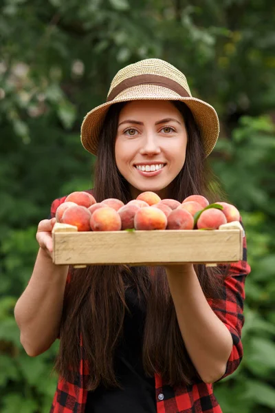 Donna giardiniere azienda pesche — Foto Stock